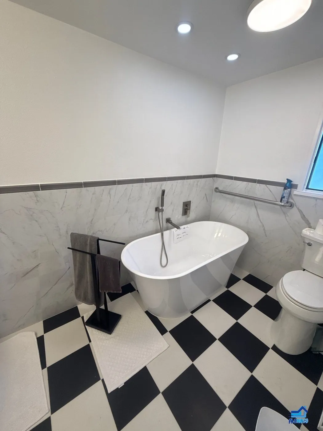 Double-sink vanity with white cabinets, black countertop ledges and a diamond checkerboard floor