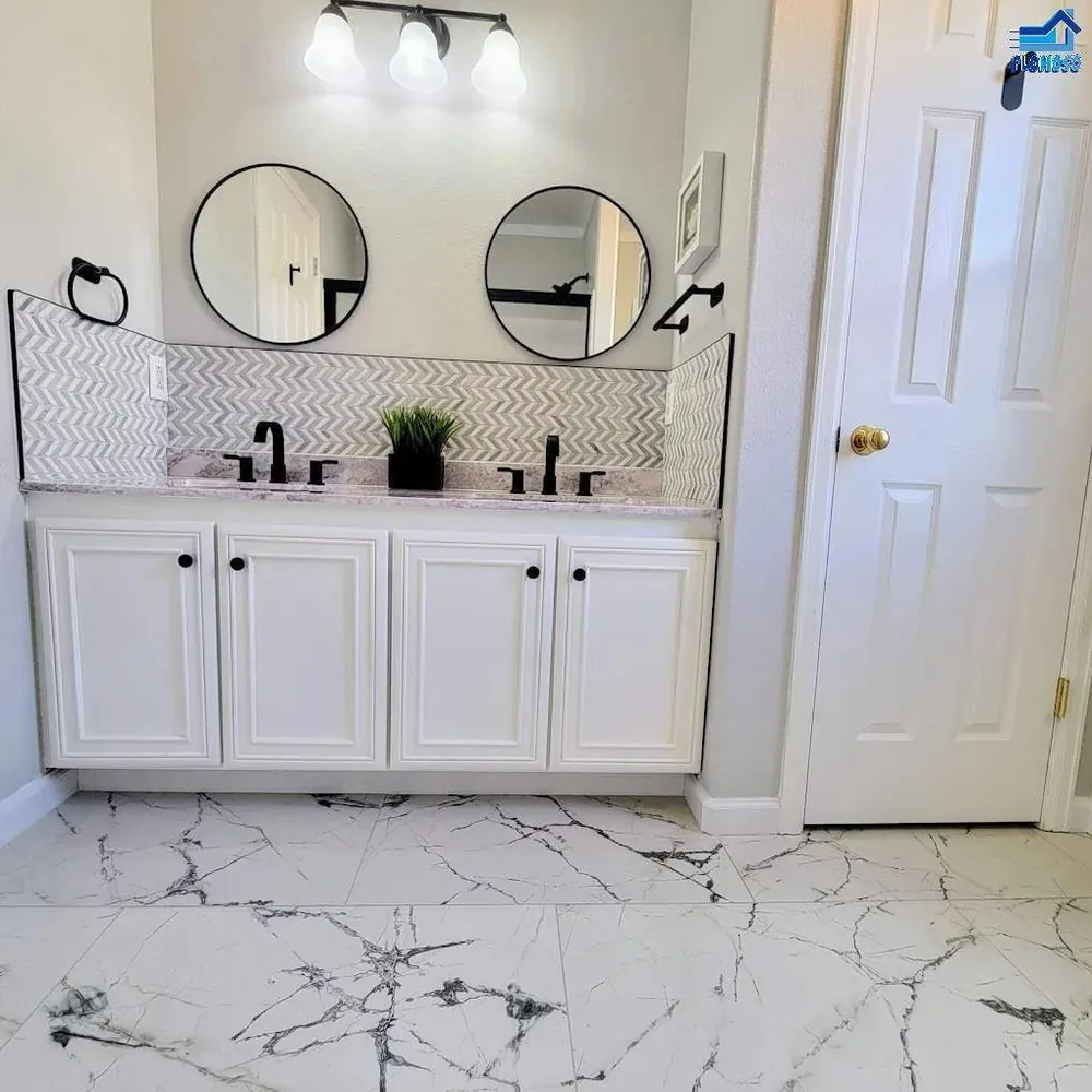 Bathroom vanity with a chevron-pattern marble mosaic backsplash and two round mirrors